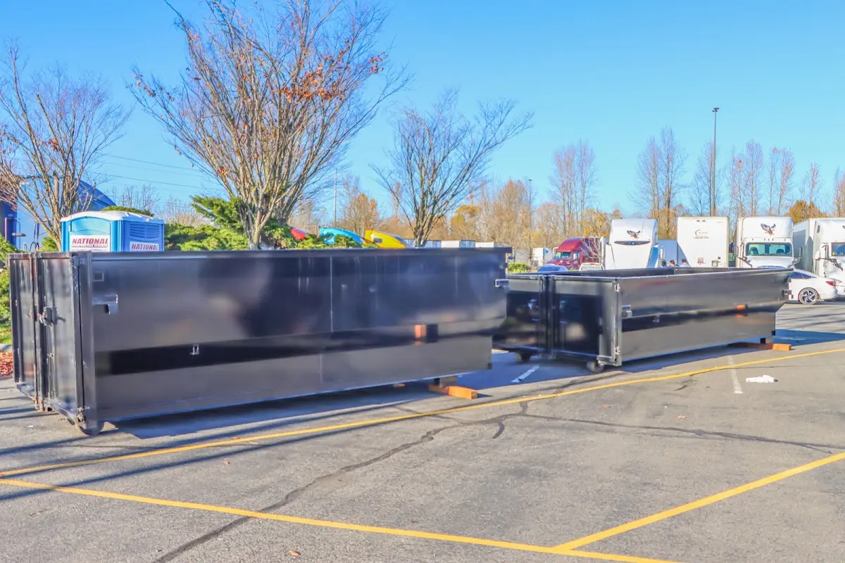Professional dumpster rental service with roll-off container on residential driveway in Baker